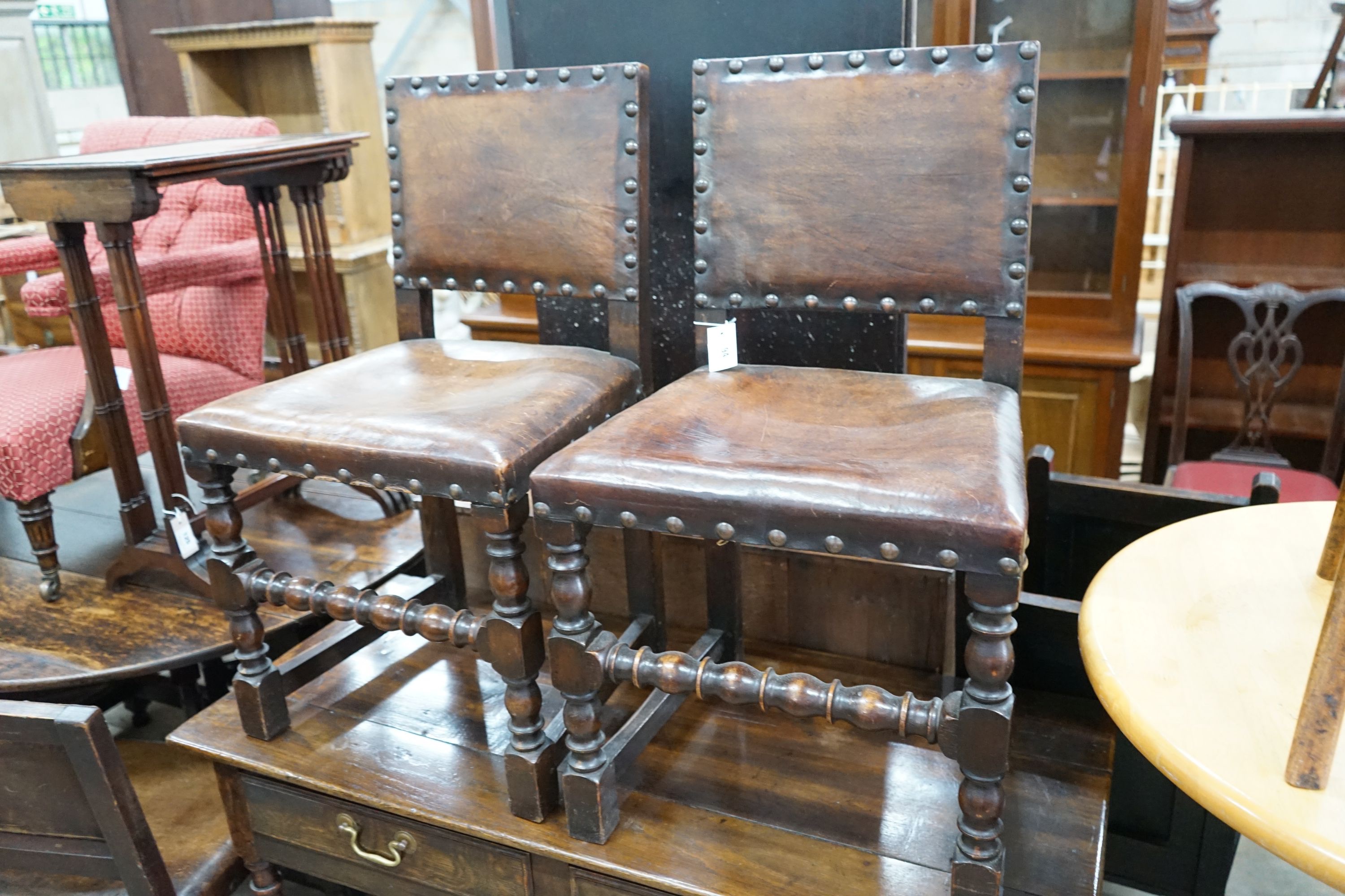 A set of six Carolean style oak and studded leather dining chairs